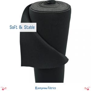 May include: A roll of black fabric, tightly wound, with a visible texture. The image includes the text "Soft & Stable" in a white box, and the brand name "Riverview Fabrics" at the bottom. The fabric appears to be thick and durable.