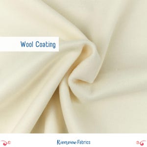May include: Close-up of a soft, white fabric with a smooth texture. The fabric is labeled "Wool Coating".