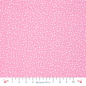 May include: Pink fabric covered in a pattern of white polka dots. The material has a smooth texture, ideal for sewing and craft projects. A ruler is visible along the bottom edge, with measurements in inches.