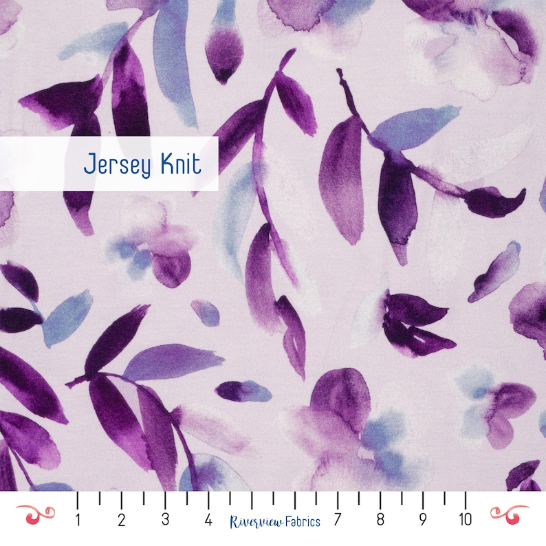 Puede incluir: Tejido de punto de jersey con un dise&ntilde;o floral de acuarela en tonos morados y azules sobre un fondo rosa claro. La tela presenta un patr&oacute;n repetido de hojas y flores, con el texto "Jersey Knit" en un rect&aacute;ngulo blanco.