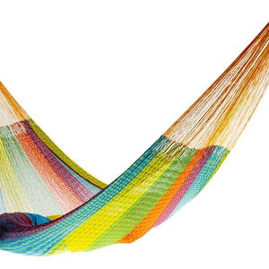 May include: A colorful striped hammock made of woven cotton. The hammock is suspended in the air and has a bright yellow, orange, green, blue, and red color scheme.