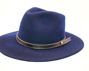 May include: A navy blue fedora hat with a brown leather band and a metal buckle.