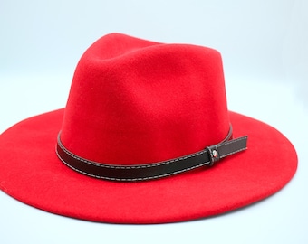 May include: A red fedora hat with a black leather band and a buckle.