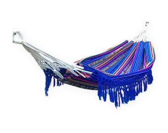 May include: A woven hammock featuring a vibrant striped pattern in shades of blue, red, yellow, and green. The hammock includes long, decorative blue fringe along the bottom edge and white braided suspension ropes at both ends for hanging.