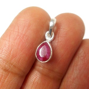 May include: A teardrop-shaped pendant with a red ruby gemstone set in sterling silver.