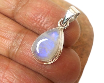 May include: A teardrop-shaped pendant with a silver setting and a white moonstone gemstone. The moonstone has a blue iridescent sheen.