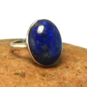 Peut inclure: Une bague en argent avec une pierre ovale en lapis-lazuli bleue.