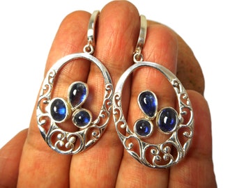 May include: Silver dangle earrings with a filigree design and three blue gemstones.