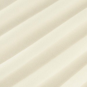 May include: A close-up of a smooth, off-white fabric with a subtle, rippled texture. The fabric has a soft, luxurious feel.