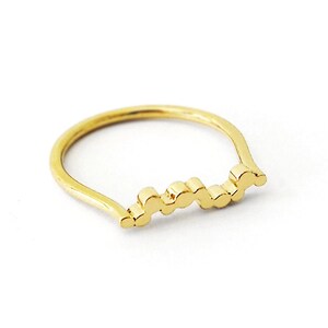 May include: A gold ring with a wavy, textured band.