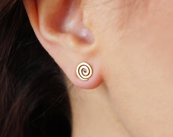 May include: A pair of gold spiral stud earrings. The earrings are small and delicate, and they are perfect for everyday wear.
