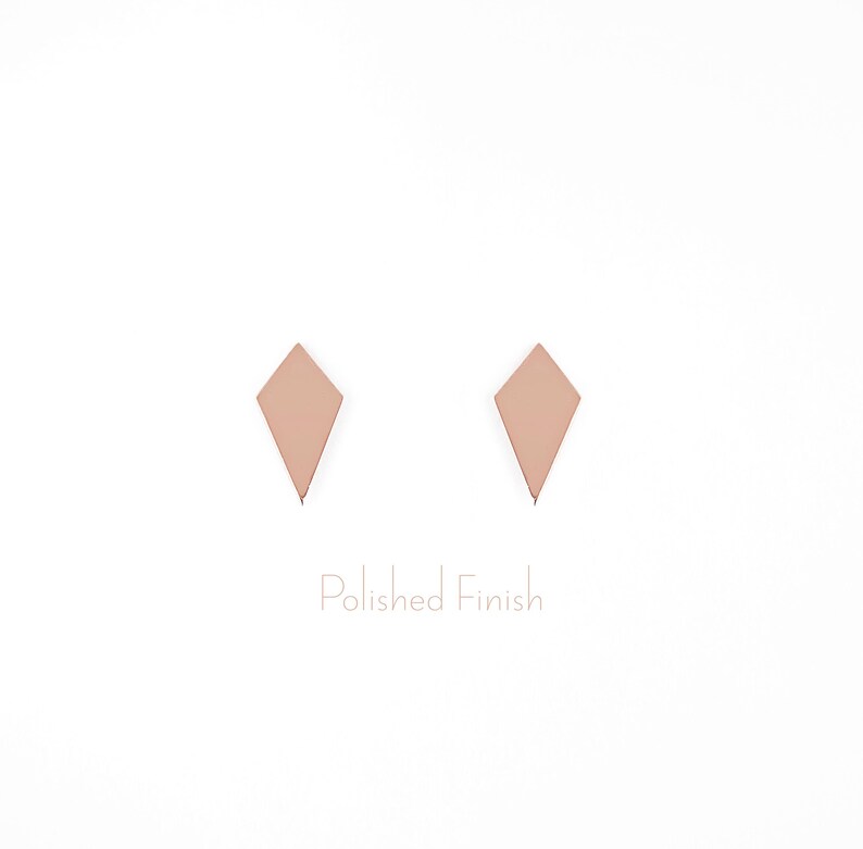 May include: A pair of rose gold diamond-shaped earrings with a polished finish.