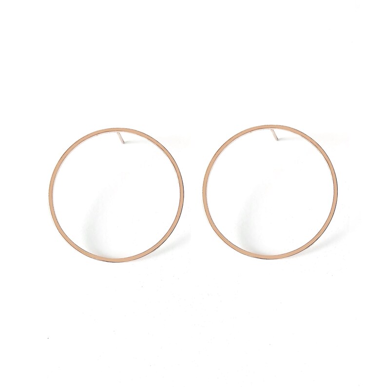 May include: A pair of rose gold hoop earrings with a simple circular design.