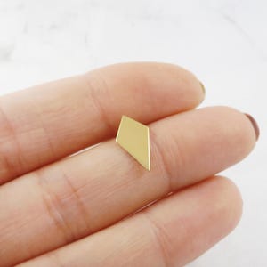 May include: A gold-colored geometric earring in the shape of a diamond.