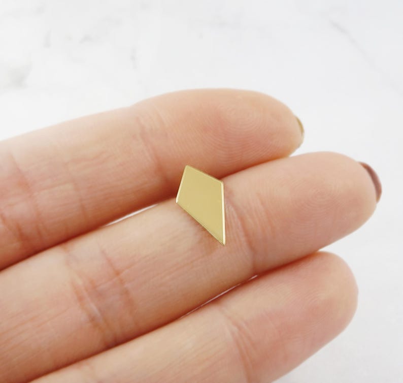 May include: A gold-colored geometric earring in the shape of a diamond.