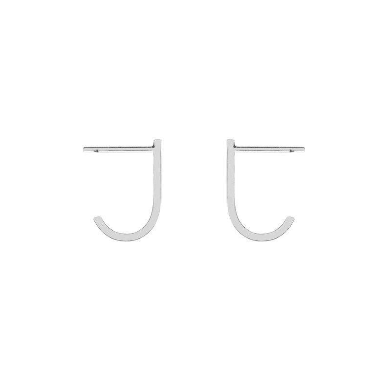 May include: A pair of silver hoop earrings with a simple, minimalist design. The earrings are shaped like a 'J' and are made of a thin, smooth metal.