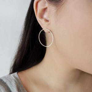 May include: A pair of gold hoop earrings. The earrings are simple and elegant, and they would be a great addition to any jewelry collection.