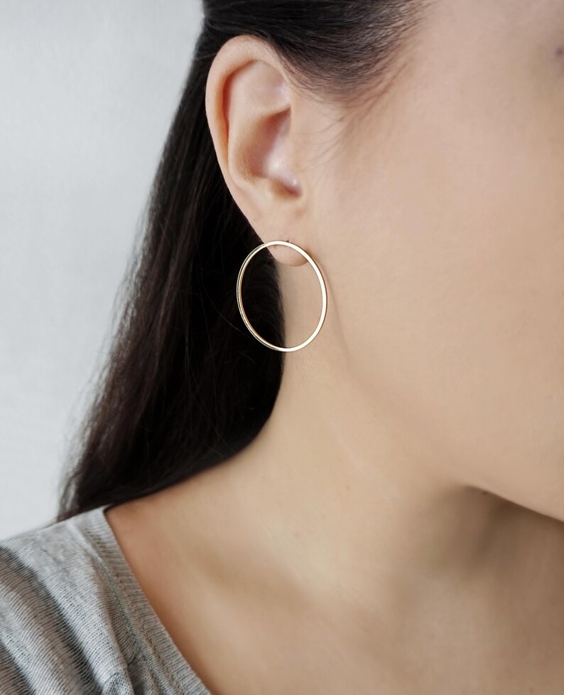 May include: A pair of gold hoop earrings. The earrings are simple and elegant, and they would be a great addition to any jewelry collection.