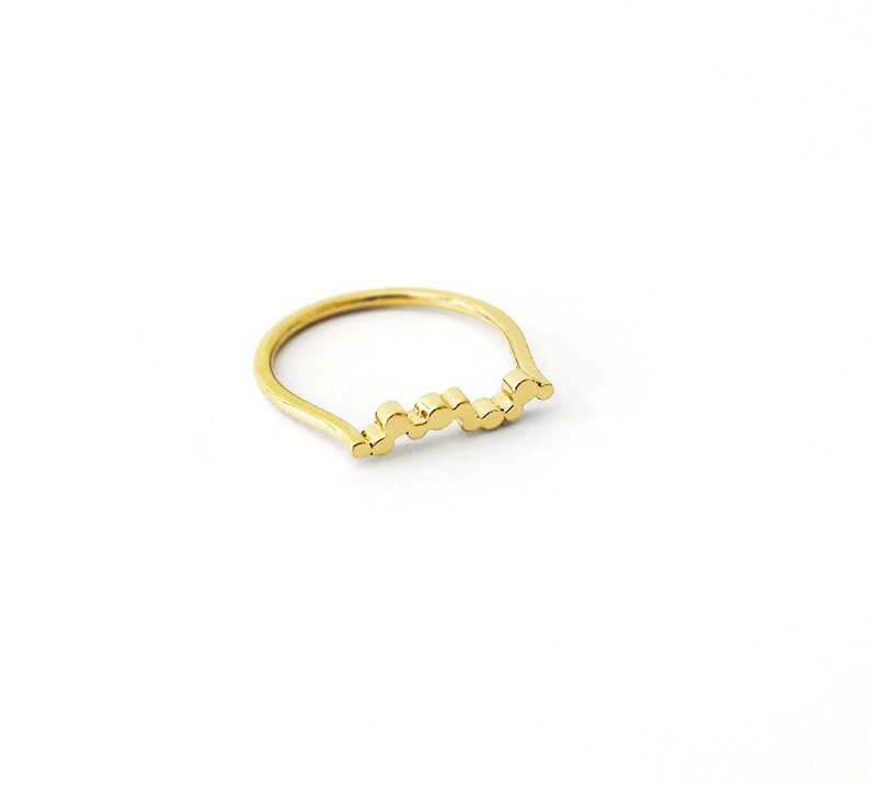 May include: A gold ring with a wavy, textured band.