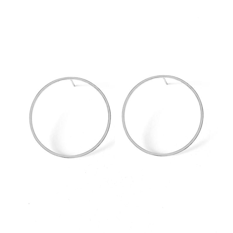 May include: A pair of silver hoop earrings with a simple circular design.