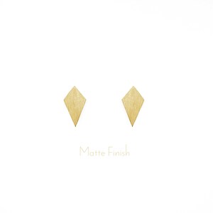 May include: A pair of gold diamond-shaped earrings with a matte finish.