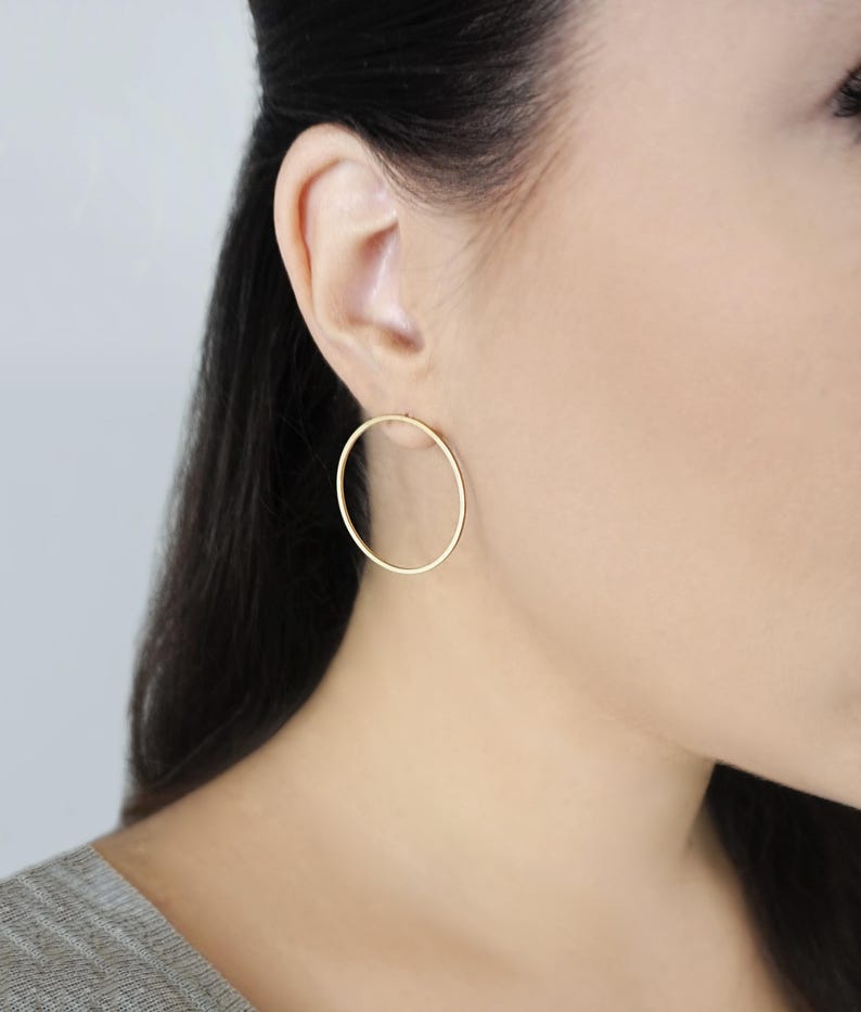 May include: A pair of gold hoop earrings. The earrings are simple and elegant, and they would be a great addition to any jewelry collection.