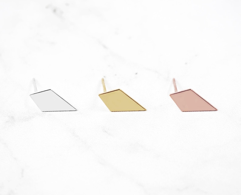 May include: Three diamond-shaped earrings in silver, gold, and rose gold.