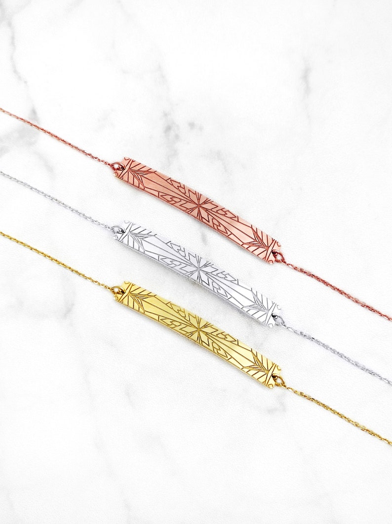 Op de afbeelding: Drie delicate kettingen met een geometrisch sneeuwvlokkenontwerp. De kettingen zijn verkrijgbaar in goud, zilver en ros&eacute; goud.