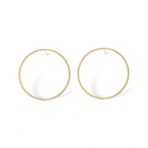 May include: A pair of gold hoop earrings with a simple circular design.