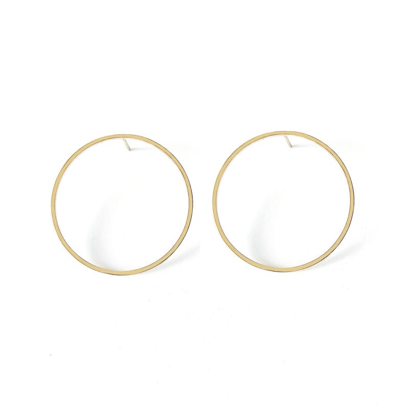 May include: A pair of gold hoop earrings with a simple circular design.