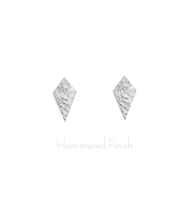 May include: A pair of silver diamond-shaped earrings with a hammered finish.