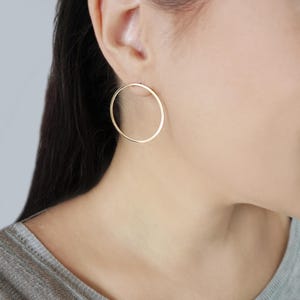 May include: A pair of gold hoop earrings. The earrings are simple and elegant, and they would be a great addition to any jewelry collection.