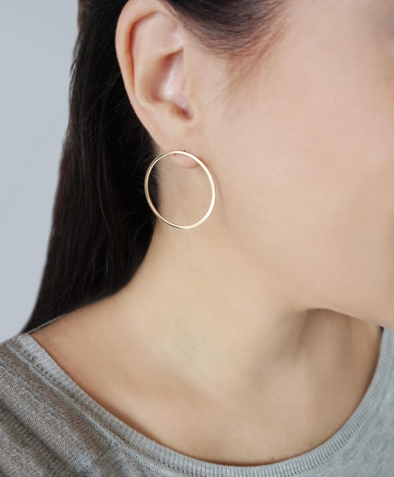 May include: A pair of gold hoop earrings. The earrings are simple and elegant, and they would be a great addition to any jewelry collection.
