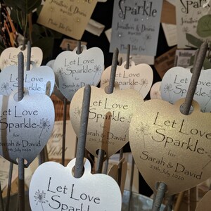 May include: A collection of heart-shaped sparklers with the text "Let Love Sparkle" and the names "Sarah & David" and the date "25th July 2020".