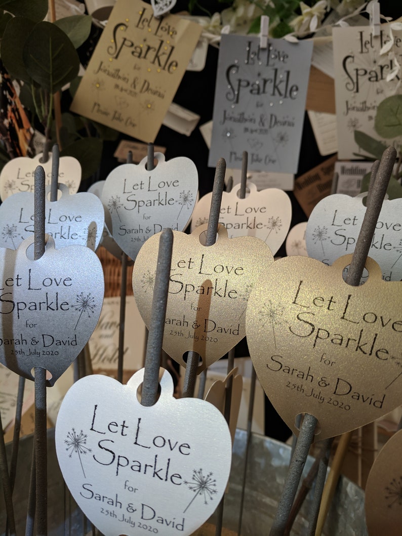May include: A collection of heart-shaped sparklers with the text "Let Love Sparkle" and the names "Sarah & David" and the date "25th July 2020".