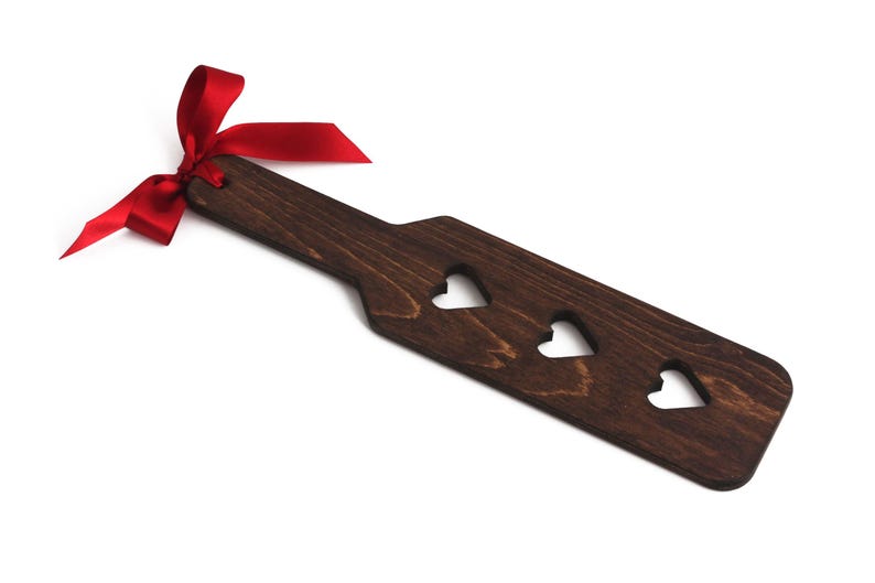 Heart cutout wooden spanking paddle. Available in three different wood stains. Spanking paddles for BDSM play.