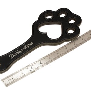 Paw paddle against ruler to show dimensions