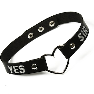Puede incluir: Collar gargantilla negro con texto plateado "YES SIR". El collar ajustable presenta un dije en forma de coraz&oacute;n plateado. La gargantilla est&aacute; hecha de material negro similar al cuero y tiene cierres de presi&oacute;n de metal plateado.