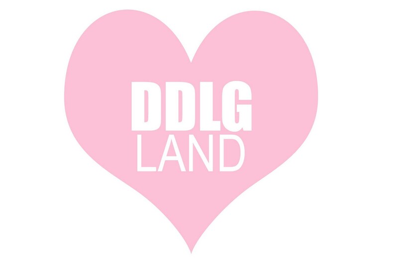 May include: A pink heart with the text "DDLG LAND" in white letters.