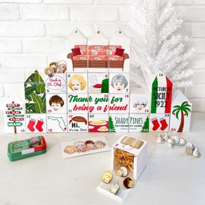 May include: A Christmas advent calendar made of wooden blocks with illustrations of the Golden Girls. Each block has a number and a different image. The calendar is decorated with a Christmas tree, a stocking, and a palm tree. The text on the blocks includes "Back in St. Olaf...", "Thank you for being a friend", "Picture it Sicily 1922", "Shady Pines Retirement Home Miami, Florida", and "Hi. It's me, Stan."