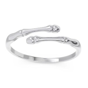 K&ouml;nnte beinhalten: Ein silberner Ring mit einem Knochen-Design. Der Ring ist offen und verstellbar.