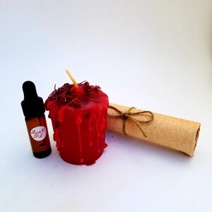 May include: A red candle with dried flowers on top, a small bottle labeled "Lust Oil", and a rolled up piece of parchment tied with twine.