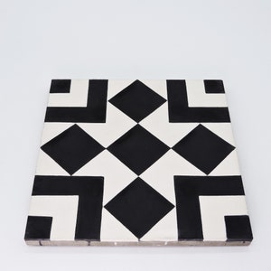 May include: Black and white geometric tile with a repeating pattern of diamonds and squares. The tile has a white background with black accents.