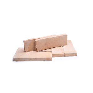 May include: A collection of light brown rectangular bricks and tiles. The bricks are stacked in a haphazard arrangement, with some lying flat and others standing upright. The color is a warm, natural tone, suggesting a material like clay or stone.