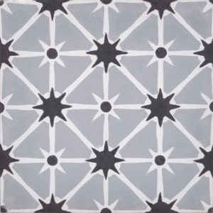 May include: A gray and white tile with a repeating pattern of black stars and circles. The stars have eight points and the circles are filled in.