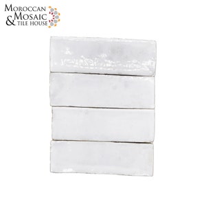 May include: Four white ceramic subway tiles stacked on top of each other. The tiles have a slightly textured surface and a slightly rounded edge.