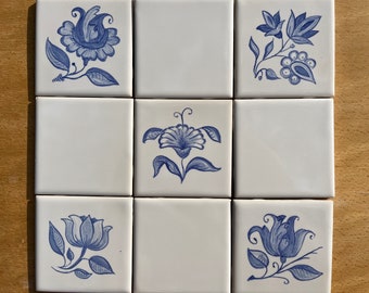 Set of nine 4.25" hand painted tiles, antique Delft style