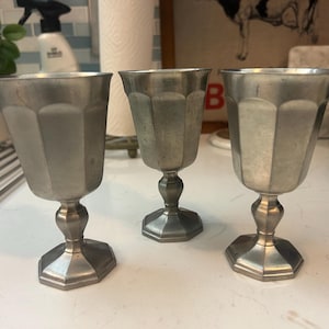 May include: A set of three ceramic vases in varying heights. The vases are white with a matte finish and feature a textured, ridged design. They are arranged on a neutral surface.