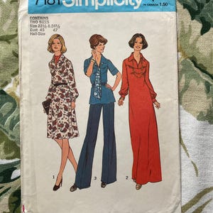 May include: Vintage Simplicity sewing pattern number 7181 for two sizes of women's clothing. The pattern includes a long-sleeved dress with a collar, a long-sleeved blouse with a collar and a scarf, and a pair of wide-legged pants.