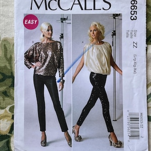 May include: A sewing pattern for a top and pants. The pattern is for sizes large, extra large, and extra extra large. The pattern is called McCall's M6653 and is labeled "Easy".